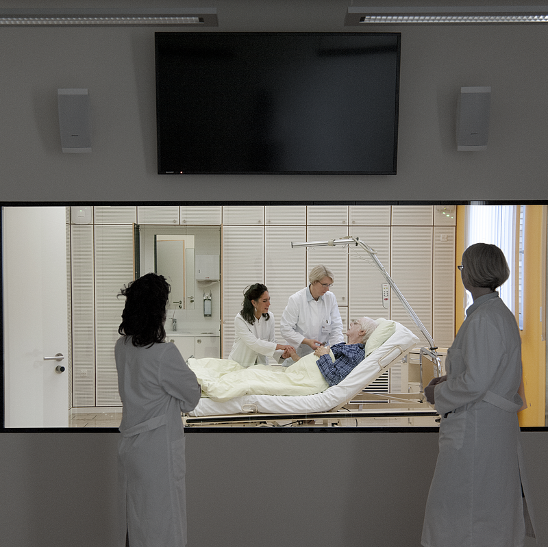 In 3 Spiegel-Doppelräumen sind jeweils 2 Räume durch einen großen, halbdurchlässigen Spiegel sowie Mikrofone verbunden. Diese Ausstattung ermöglicht es in einem Raum ungestört Szenarien des klinischen Alltags zu trainieren während die Simulation gleichzeitig im Nachbarraum begleitet, beobachtet und nachbesprochen werden kann.